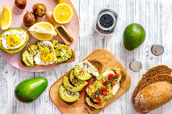 Desayuno con aguacate, zumo, tomates, tostadas y café